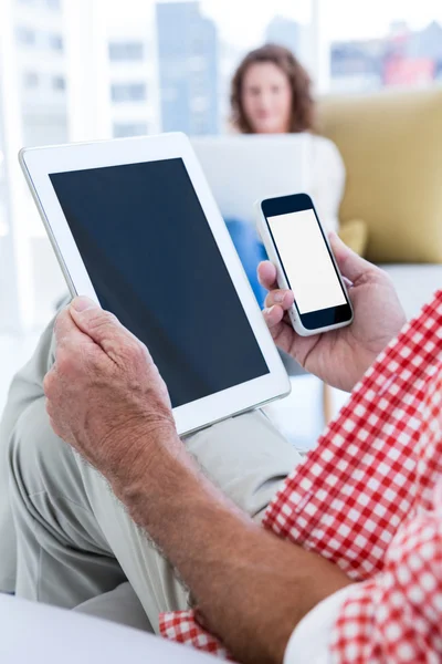 Hombre sosteniendo tableta y teléfono — Foto de Stock