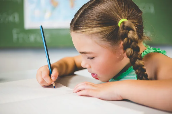 Colegiala haciendo la tarea en el aula —  Fotos de Stock