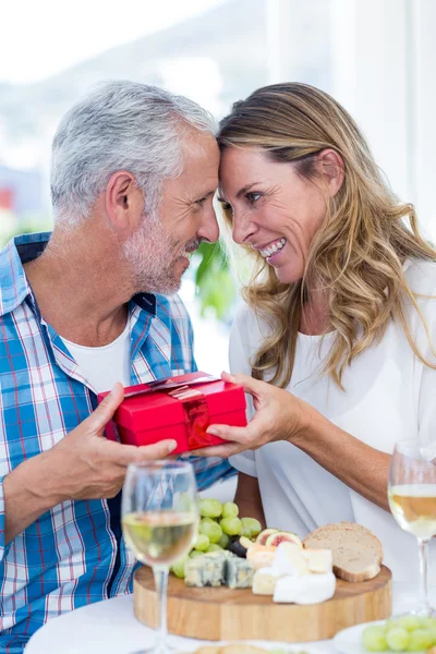 Casal romântico com presente no restaurante — Fotografia de Stock