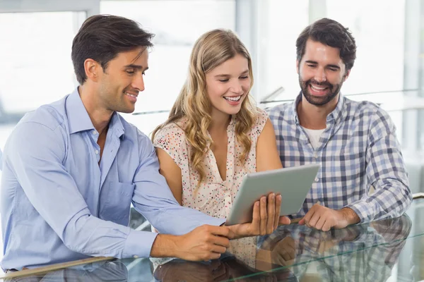 Femme souriante et deux hommes utilisant une tablette numérique — Photo