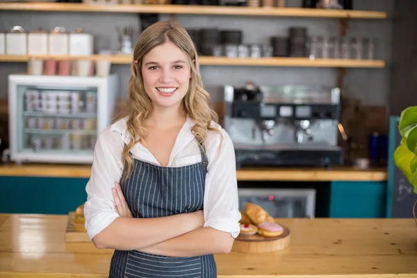 Portrait of smiling waitress standing with arms crossed — Stock Photo, Image