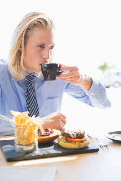 Человек, пьющий кофе и завтракающий — стоковое фото