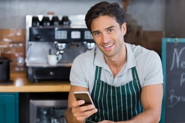 Портрет улыбающейся официантки с помощью мобильного телефона — стоковое фото