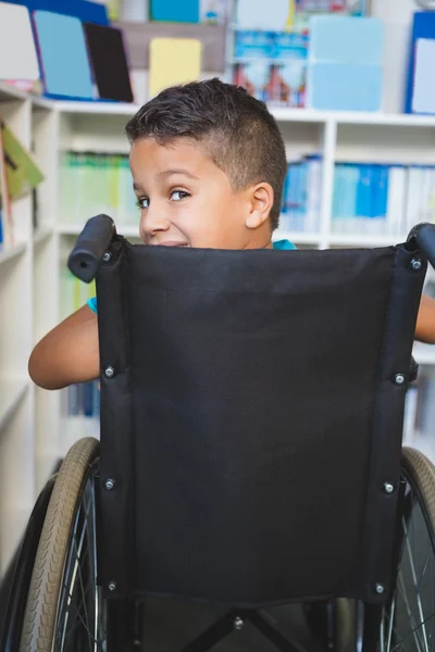 Disabled schoolboy in library — Stock Photo, Image