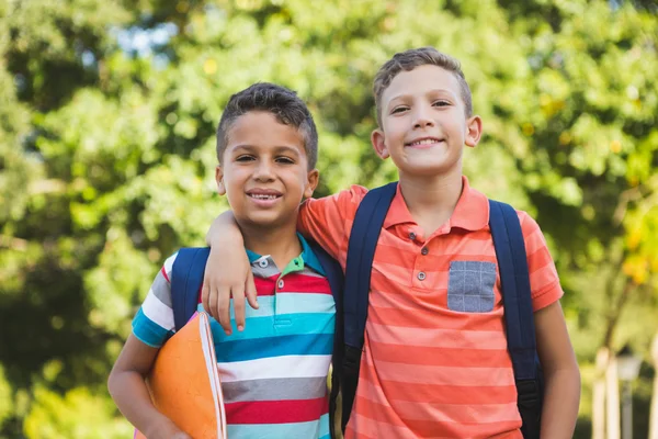 Smiling schoolkids standing in campus — Stock Photo, Image