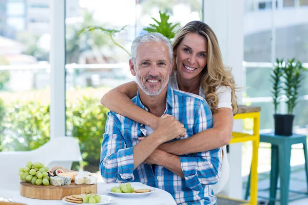 Woman embracing husband in restaurant — Stock Photo, Image