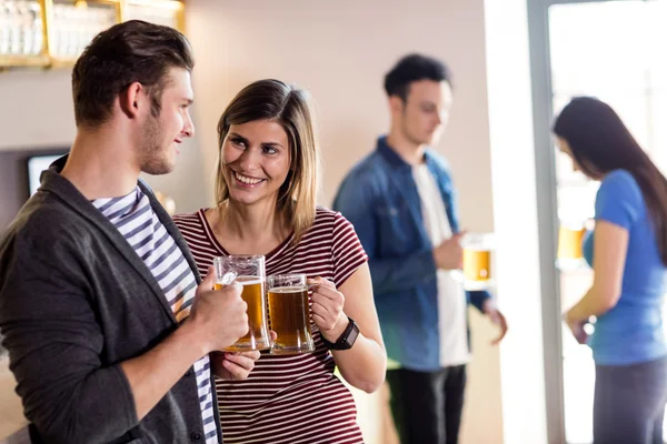 Pár s džbánky na pivo v baru — Stock fotografie