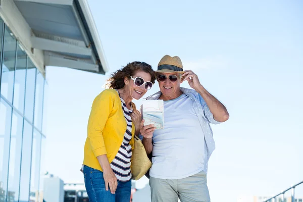 Echtpaar met zonnebril kaart lezen — Stockfoto