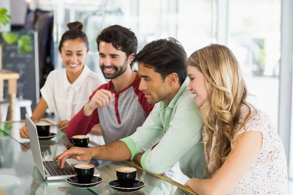 Grupo de amigos usando el ordenador portátil mientras toma una taza de café —  Fotos de Stock