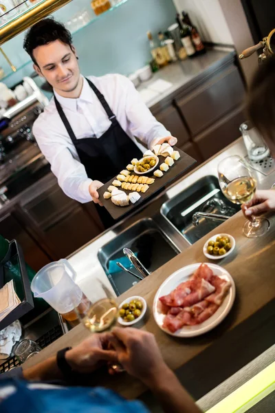 Bartender melayani makanan untuk pelanggan — Stok Foto