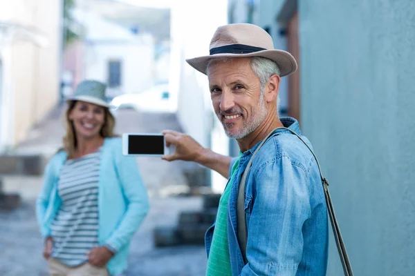 Homem fotografando mulher na cidade — Fotografia de Stock