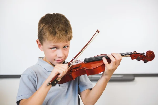 Portrait of smiling schoolboy playing violin in classroom — Stock Photo, Image