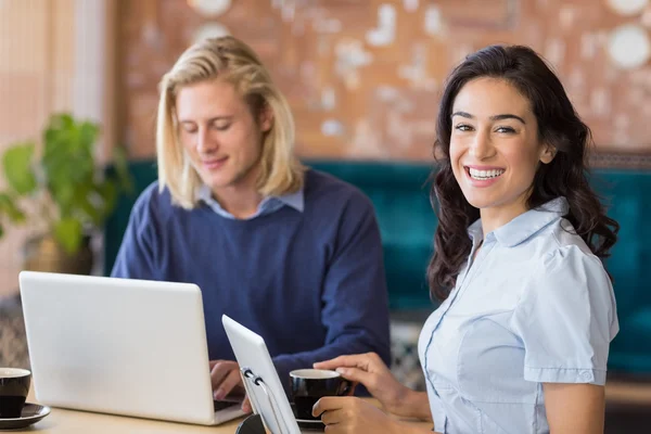 Compañeros de negocios que utilizan portátil y tableta digital — Foto de Stock