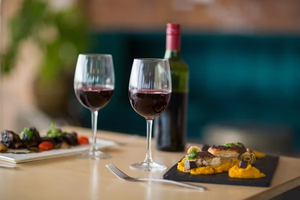Plate of meal with glass of red wine — Stock Photo, Image