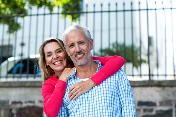 Paar staande tegen hek — Stockfoto