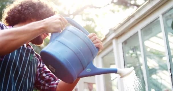 Gärtner gießt Pflanzen mit Gießkanne — Stockvideo