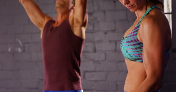 Vrouw en man trainen met halters en kettlebell — Stockvideo