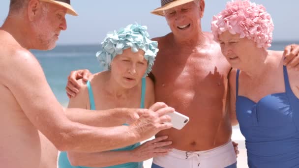 Senior vrienden op zoek naar een smartphone en lachen — Stockvideo