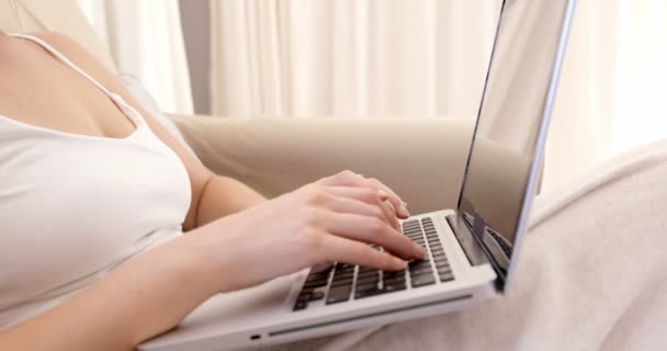 Γυναίκα χρησιμοποιώντας φορητό υπολογιστή στον καναπέ της — Αρχείο Βίντεο