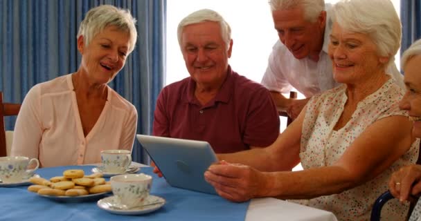 Seniorenfreunde schauen auf digitales Tablet — Stockvideo