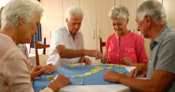 Senior vrienden praten tijdens het spelen van dominos — Stockvideo