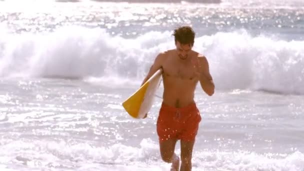 Surfer läuft, um aus dem Wasser zu kommen — Stockvideo