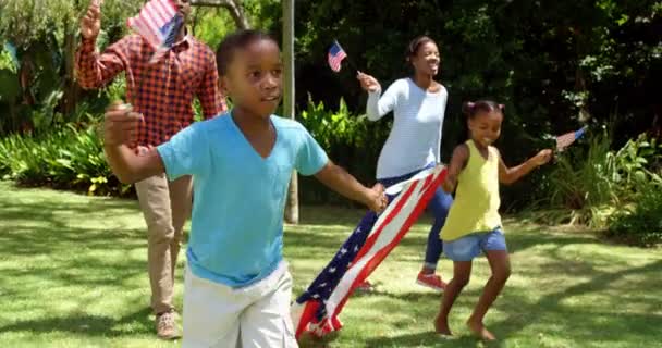 Familia corriendo con banderas americanas — Vídeo de stock