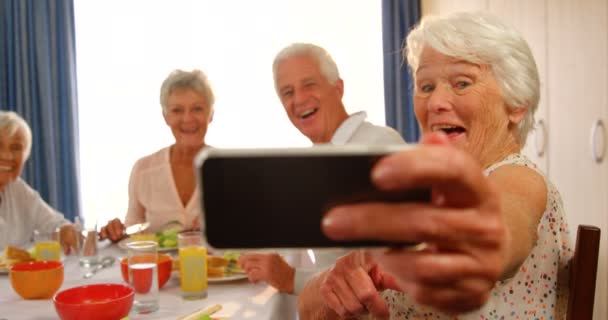Mujer mayor tomando una selfie con sus amigos — Vídeo de stock