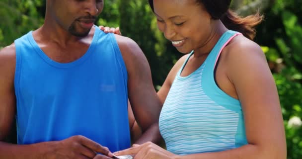 Sporty casal olhando relógio inteligente — Vídeo de Stock