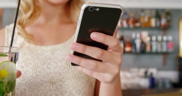 Женщина с телефоном во время коктейля — стоковое видео