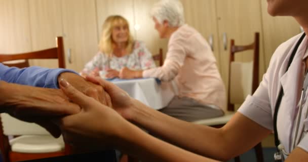 Arzt hält Hand einer Seniorin, die im Rollstuhl sitzt — Stockvideo