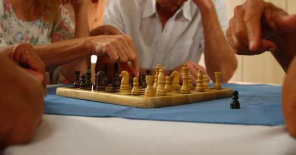 Mitten delen av senior vänner spelar schack — Stockvideo