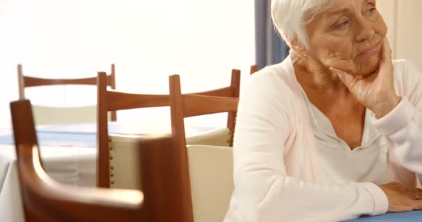 Несчастная пожилая женщина сидит одна — стоковое видео
