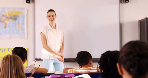 Female teacher standing in front of whiteboard Stock Video