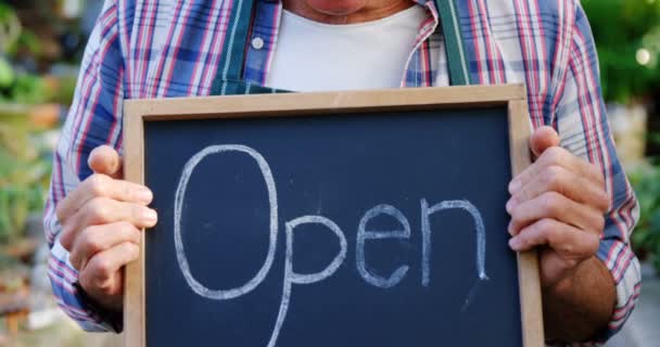 Mature man holding open sign — Stock Video