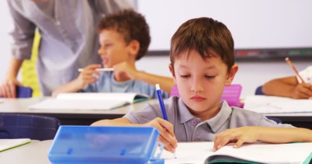 Profesor ayudando a niño a escribir en el cuaderno — Vídeo de stock