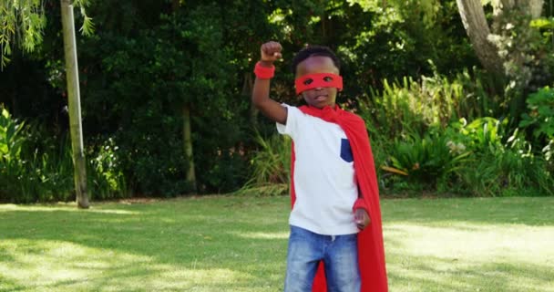 Маленький хлопчик позує в костюмі супергероя — стокове відео