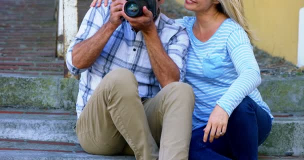 デジタル カメラの写真を探しているカップル — ストック動画