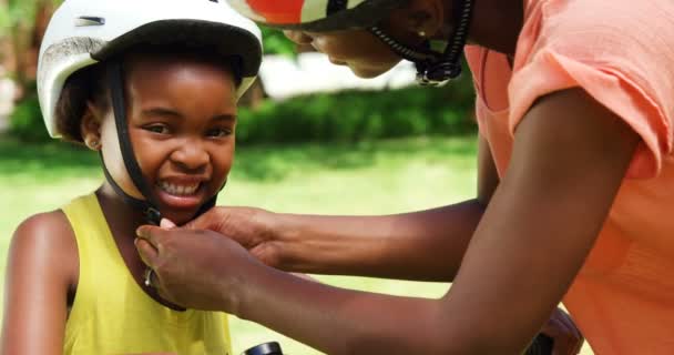 Donna mettendo casco da ciclismo a figlia — Video Stock