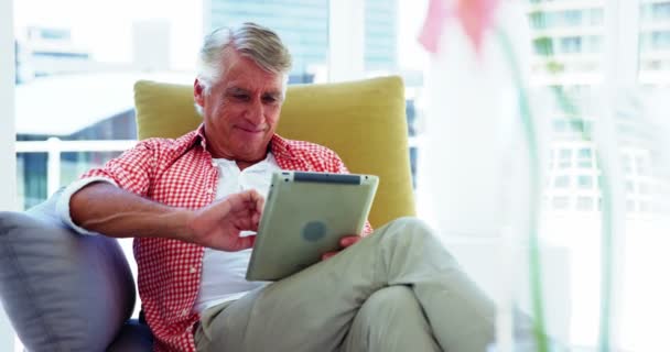 Uomo maturo sul divano e utilizzando tablet — Video Stock