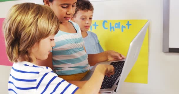 Drie kinderen met behulp van een laptop — Stockvideo