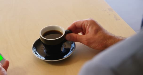 Επιχειρηματίας χρησιμοποιώντας τηλέφωνο κρατώντας καφέ — Αρχείο Βίντεο