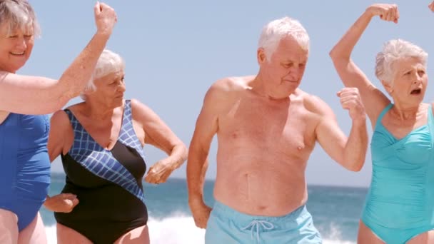 Старші друзі танцюють на пляжі — стокове відео