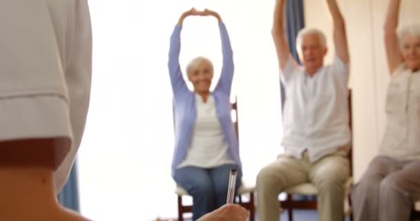 Терапевт помогает людям с физическими упражнениями — стоковое видео