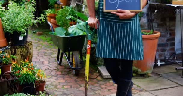 Садовник держит открытый знак — стоковое видео