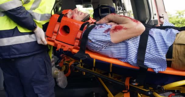 Tıbbi teknisyenler yaralı bir kişi holding — Stok video