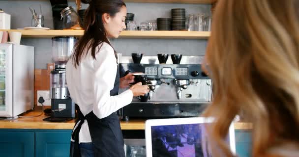 Serveuse servant une tasse de café à une femme — Video