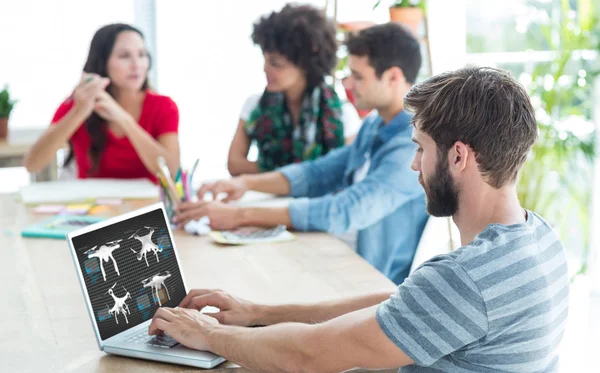 Imagen compuesta de hombre de negocios casual escribiendo en su computadora portátil — Foto de Stock