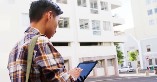 Homem andando e usando um computador tablet — Vídeo de Stock