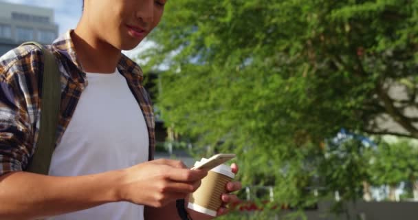 Hombre mensajes de texto en el teléfono inteligente y la celebración de café — Vídeos de Stock